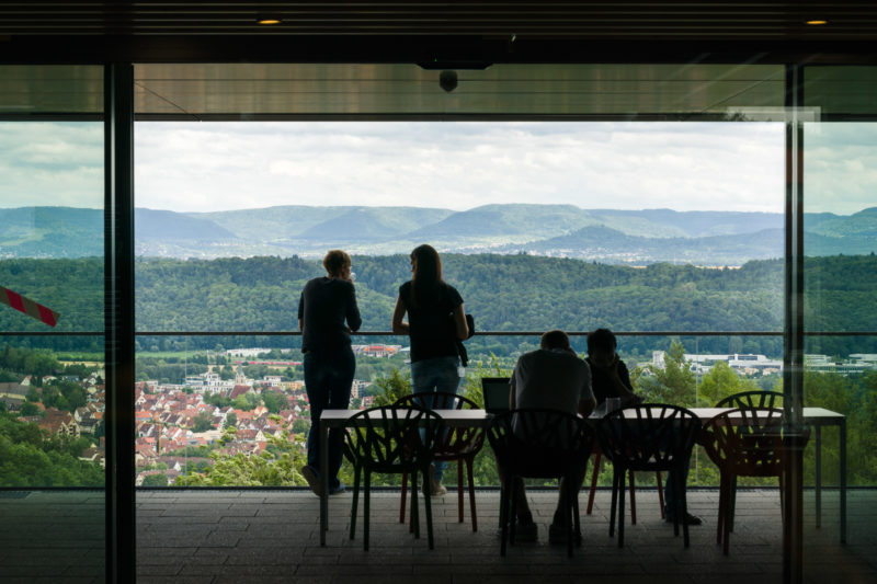 Architekturfotografie: Wissenschaftler im Neubau eines Forschungsinstituts in Tübingen haben von der Cafeecke aus einen schönen Blick auf die bewaldete Hügellandschaft der schwäbischen Alb und auf die Stadt.