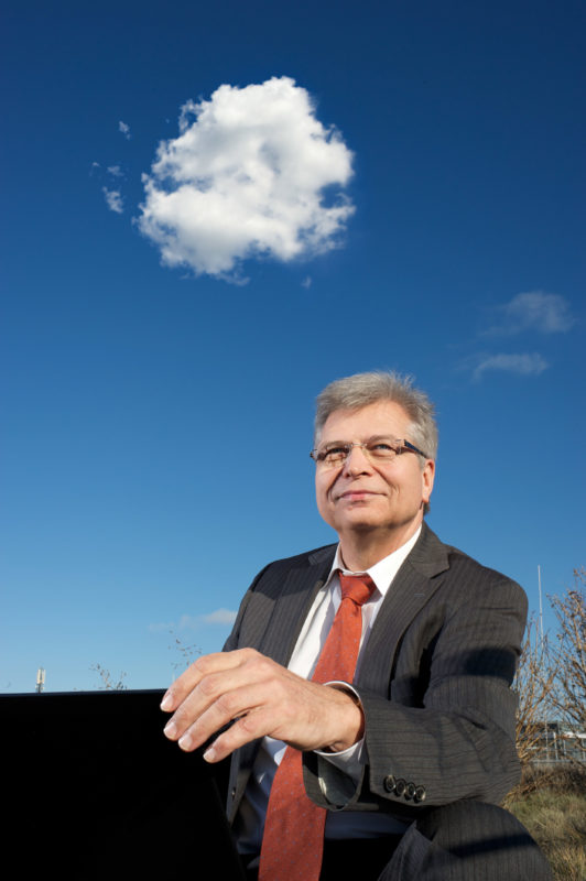 Mitarbeiterfotografie: Ein Spezialist für Cloud-Computing draußen. Am Himmel eine weisse Wolke.