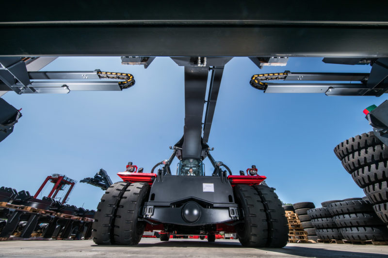 Industrial photography: Container handler with yellow-black cable guides on the adjustable outriggers of its lifting frame.