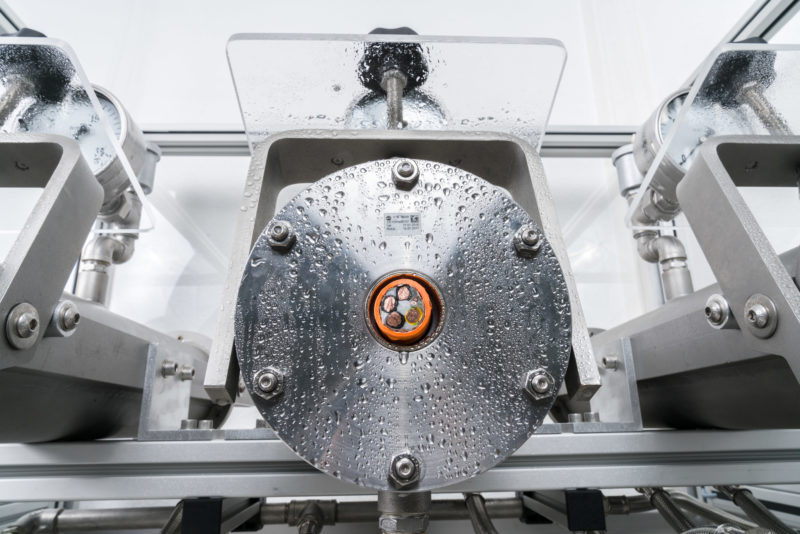 Industriefotografie: In einem Prüflabor: Dichtigkeitsprüfung an der Isolierung eines Spezialkabels für Maschinen.