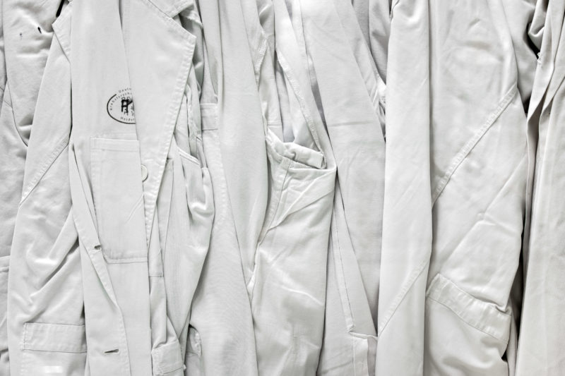 Science photography: Scientific photography:  White researchers coats hanging at a glass partition in the in the clean room laboratory at German Cancer Research Center in Heidelberg.