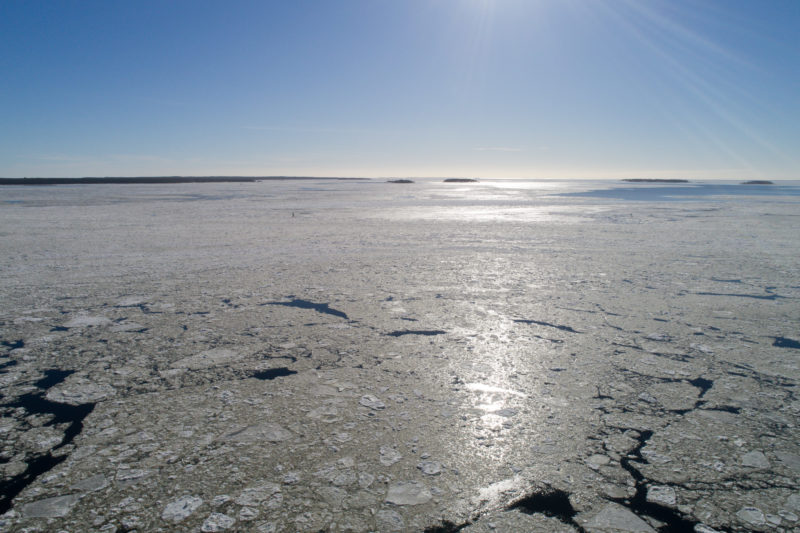 Luftaufnahmen und Drohnenfotografie: Die mit einer Drohne fotografierte Gegenlichtaufnahme zeigt die vereiste Ostsee vor Finnland bei bestem aber sehr kaltem Wetter.