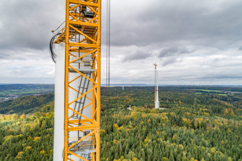 Aerial and Drone photography: At the top of the tower of a wind turbine, which is currently under construction, cables protrude which will later carry the electrical current from the nacelle downwards.