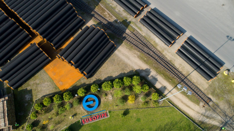 Aerial and Drone photography: Vertical view from above of stored large steel pipeline pipes.