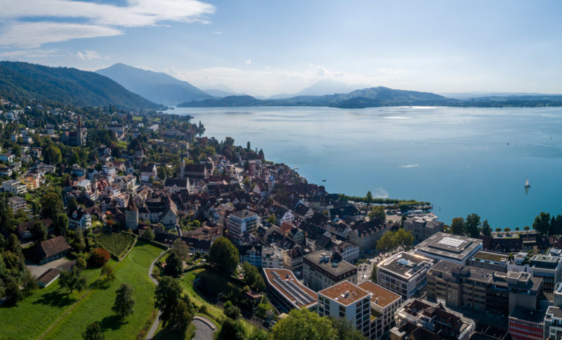 Stadtportrait: Zug am Zuger See. Luftaufnahmen und Drohnenfotografie: Drohnenfoto der Stadt Zug am Zuger See in der Schweiz bei bestem Wetter.