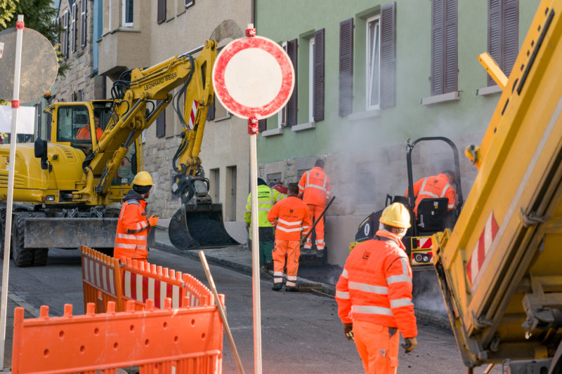 Reportagefotografie auf einer Glasfaserbaustelle: Das Verlegen von schnellem Internet in städtischem Umfeld ist sehr aufwändig und erfordert trotz dem Einsatz von Maschinen auch viel Handarbeit.