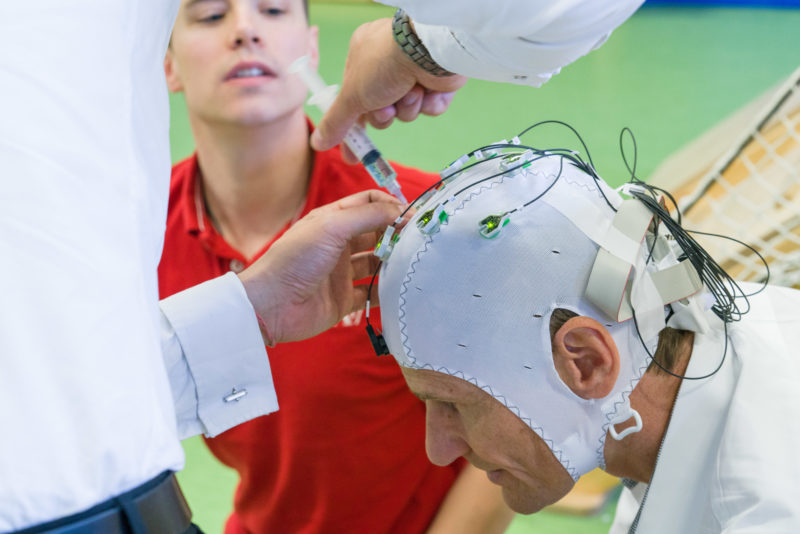 Wissenschaftsfotografie: Hirnforschung an der Universitaet Tuebingen: Einem Proband wird eine Elektrodenkappe zur Messung von Hirnströmen angelegt. Unter Leitung von Dr. med. Surjo R. Soekadar der Arbeitsgruppe Angewandte Neurotechnologie wird das im Gehirn unbewusst entstehende Bereitschaftspotential kurz vor einem waghalsigen Sprung des Probanden gemessen. Ziel ist die Messung des Bereitschaftspotentials im Alltag, mit dem man willentliche Bewegungen erkennen kann, bevor der Proband seine Entscheidung zur Bewegung selbst wahrnimmt.