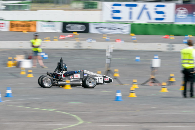 Reportagefotografie: Formula Student Germany: Ein Rennwagen auf dem Rundkurs, an dem seine Eigenschaften und die Fähigkeit des Fahrers gemessen werden.