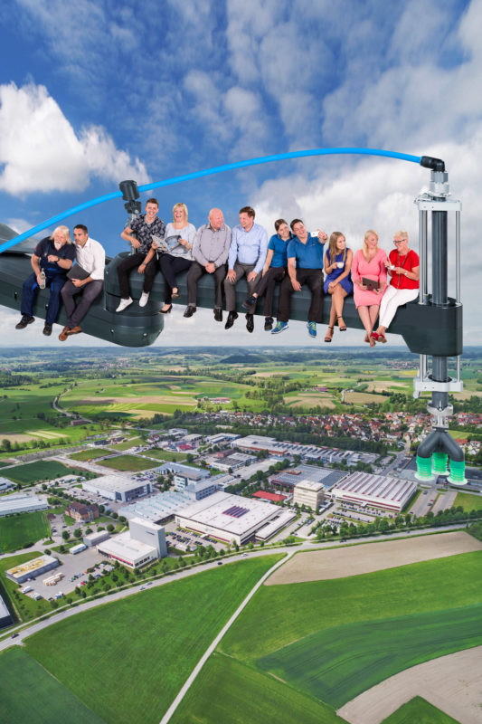 Photomontage with Photoshop: Photomontages with Photoshop:  In the style of the famous photo of pausing skyscraper workers from New York, employees of a manufacturer of packaging machines sit on a machine arm that floats above the company.