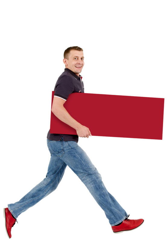 Employees photography: For a personnel campaign of a vehicle manufacturer, employees pose with a red sign against a white background. The photos are full body shots and each person acts differently in front of the camera. Here an employee walks with a long step through the picture.