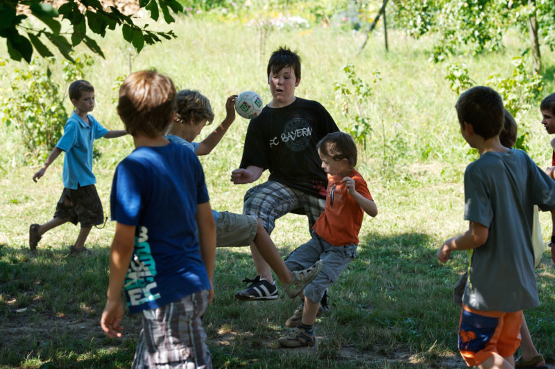 Editorial photography: At a primary school the boys play football during the break in the school garden.