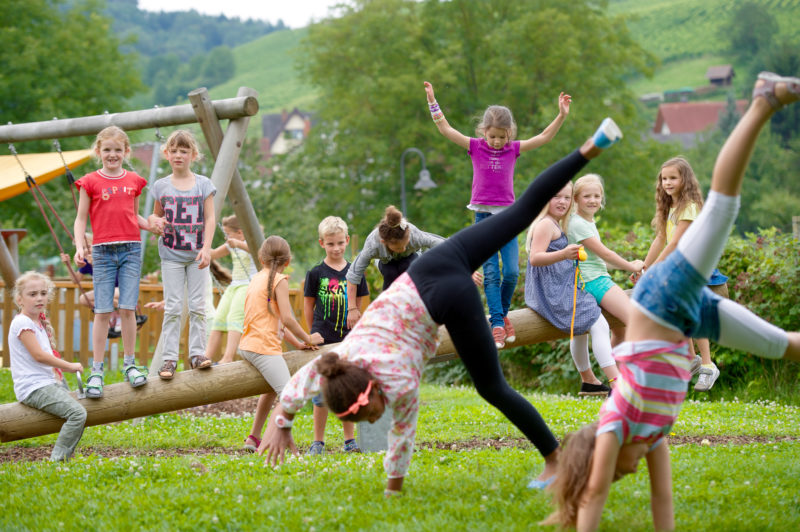 Reportagefotografie zum Thema Lernen und Bildung: Reportagefotografie: Während der Pause an einer Grundschule tollen die Mädchen draußen im Schulgarten umher.