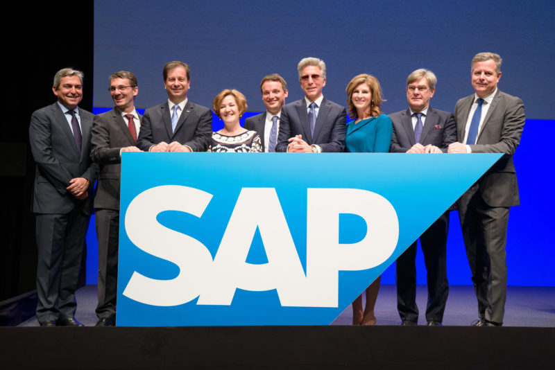 Gruppenfoto: Gruppenbild der Geschäftsführung der SAP SE zu Beginn der Aktionsversammlung. Alle stehen auf der Bühne hinter einem großen SAP-Logo.