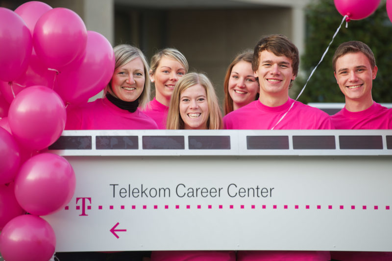 Group photo: A group of trainees is behind the label of the Telekom Career Center in Bonn.