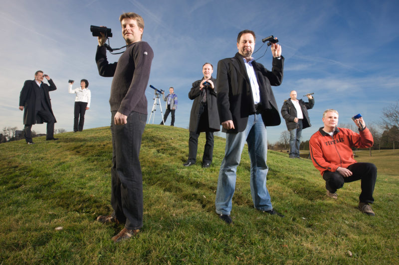 Group shot: Employees Portrait: Group photo of employees of a department for Trend Research. They stand on a hill and look through binoculars.