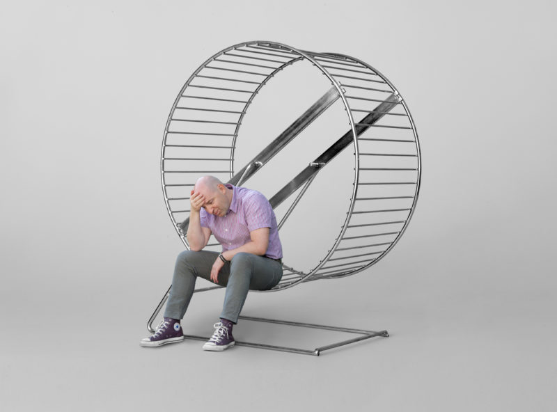 Photomontage with Photoshop: A man sitting exhausted in the rat race.