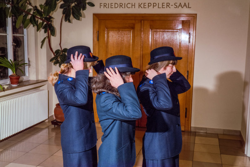 Editorial photography at the Salvation Army: Three young cadet girls put on the official officer