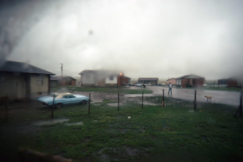 Reportagefotografie auf Diafilm in der Pine Ridge Reservation in South Dakota, USA: Bei Regen wirken die Hütten einer der typischen Reservatsiedlungen noch deprimierender.