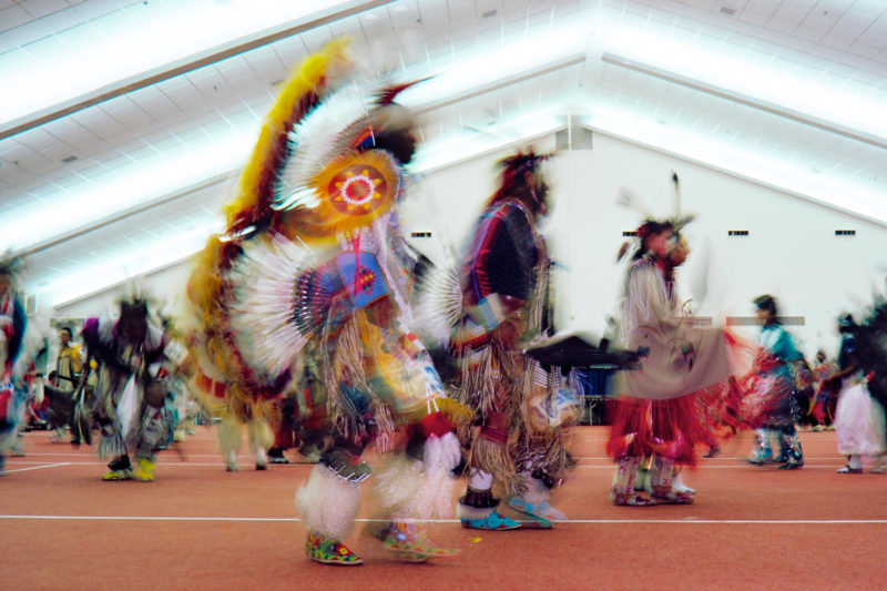 Reportage photography on slide film in the Pine Ridge Reservation in South Dakota, USA: Dancers from different Indian tribes at a dance competition in a community hall on the reservation.