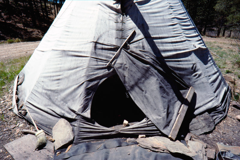 Reportage photography on slide film in the Pine Ridge Reservation in South Dakota, USA: An abandoned Indian tent in a forest where members of the American Indian Movement meet.