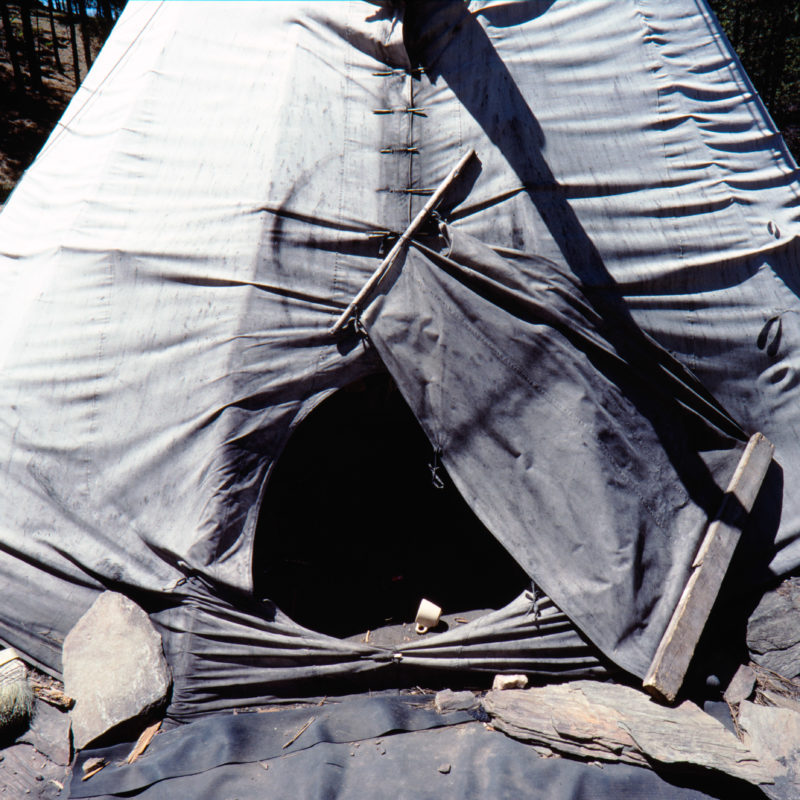 Luftaufnahmen und Drohnenfotografie: Reportagefotografie auf Diafilm in der Pine Ridge Reservation in South Dakota, USA: Ein verlassenes Indianerzelt in einem Wald, in dem sich Mitglieder des American Indian Movement treffen.