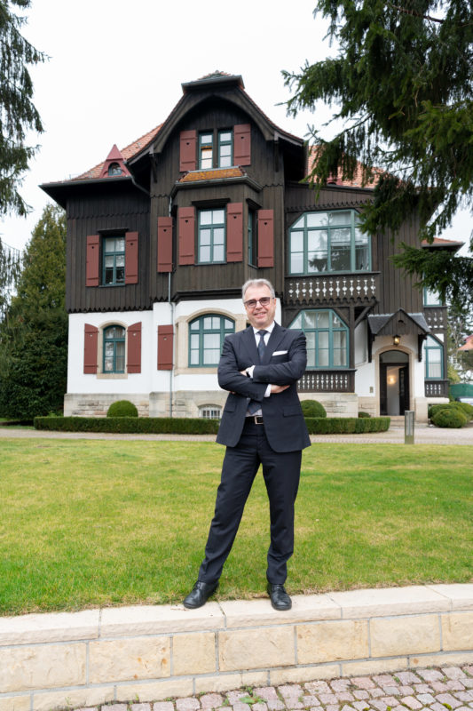 Interview photos: Portraits during a conversation with an economic expert. A full body portrait is essential for a good lead picture. Here the interviewee is standing in front of the company headquarters.