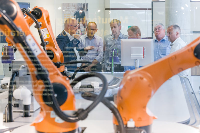 Technikfotografie: Besucher einer Führung zur Internet of Things iOT Demontstrationsanlage bei SAP SE in Walldorf, bei der vernetzte Fertigungstechnik vorgeführt wird.