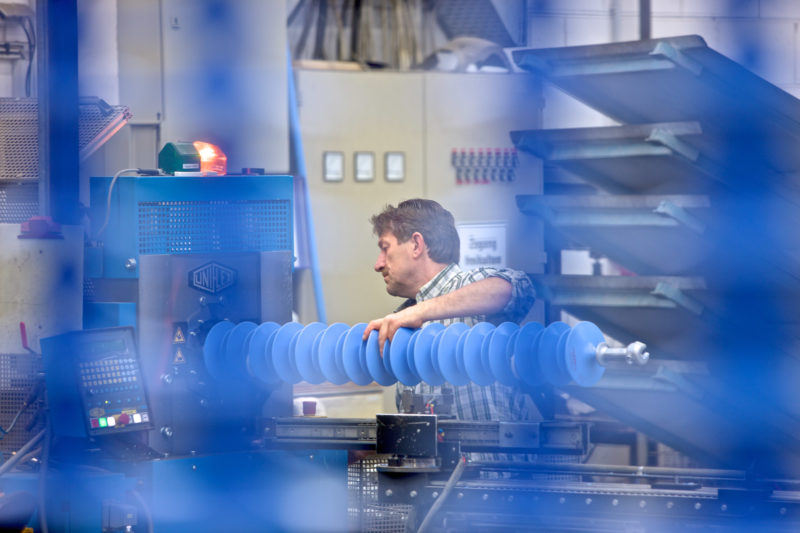 Industrial photography: Processing of blue insulators for suspension of high-voltage lines.