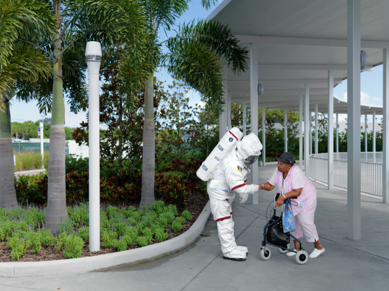 editorial photography: A Costumed astronaut welcomes an elderly woman in the visitor area.