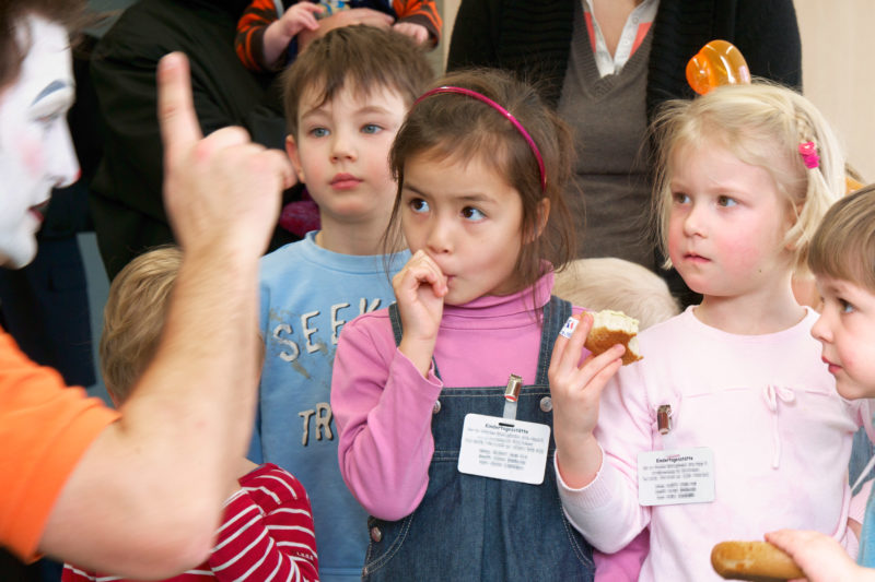 Reportagefotografie zum Thema Lernen und Bildung: Reportagefotografie: Eröffnung eines Kinderhorts. Ein Clown unterhält die Kinder.