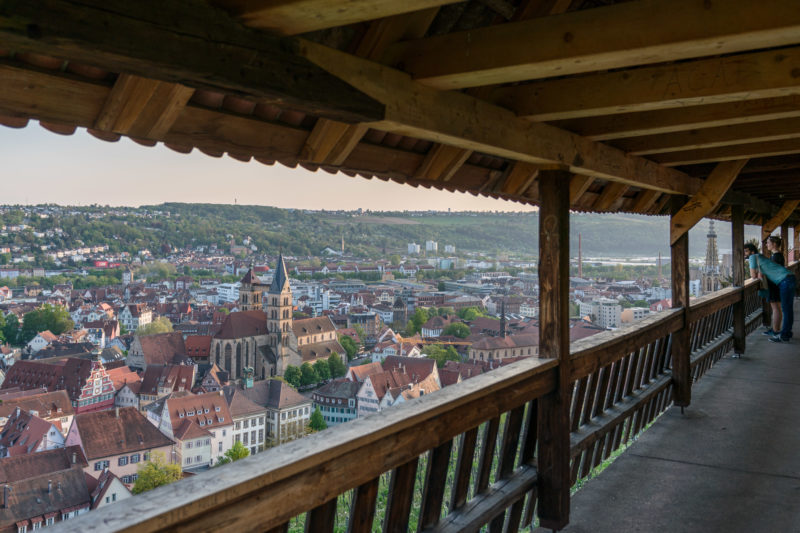 Landscape photogaphy: A couple looks from the castle above the vineyards to the city of Esslingen on the Neckar in the evening light.