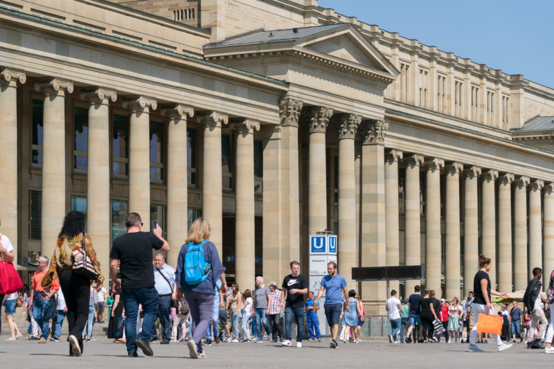 Cityscape photography of Stuttgart: City view from the summery Stuttgart: In front of the columns of the Königsbau many pedestrians are on the way on the Königsstraße.