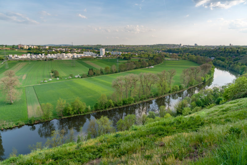 Landschaftsfotografie: Blick auf eine Neckarschleife bei Marbach. Die Landschaft ist grün und im Hintergrund sieht man Siedlungen.