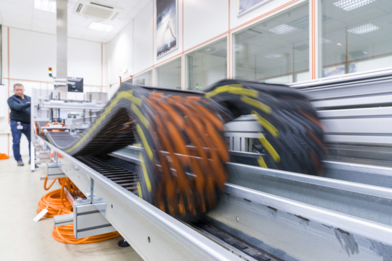 Industry photography: In a test laboratory: In the test centre of a cable manufacturer, cables are automatically moved back and forth hundreds of thousands of times in a cable chain guide in order to test long-term stability against cable breakage.