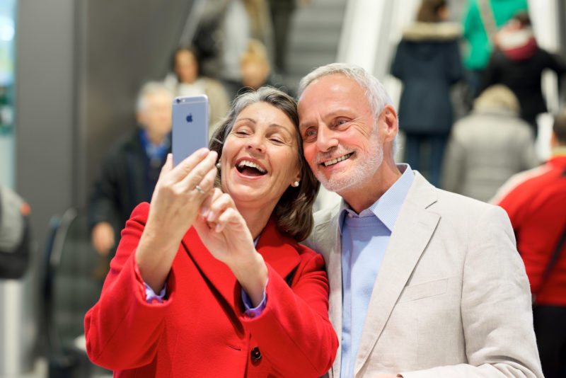 Selfie: Senior Couple in a mall makes a self portrait with their smartphone.