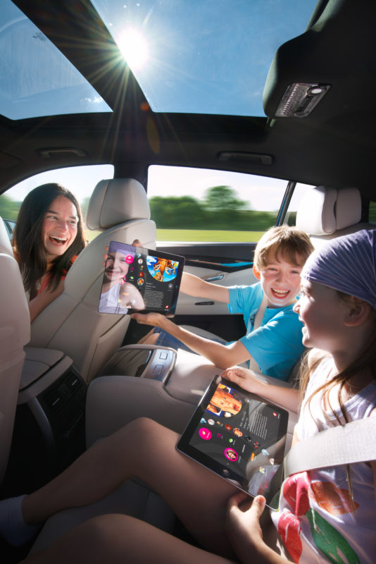 Industriefotografie: Lifestyle-Fotografie: Eine Familie im Auto auf einen Ausflug. Die Kinder surfen auf den Rücksitzen mit Tablet-Computern im Internet.