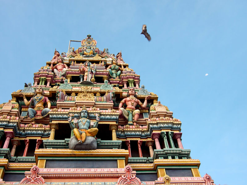 travel photography: Mauritius: Hindu temple in front of a blue sky with flying dove and crescent moon.