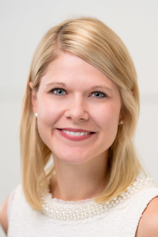 Portrait photography: Portrait of an employee illuminated with studio flash in front of a neutral background. The sharpness is almost exclusively on the eyes of the person by using the fully open aperture of a fast lens.