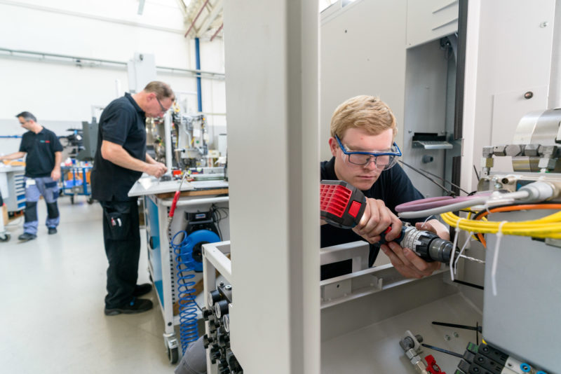 Industriefotografie: Ein Mitarbeiter bohrt bei einem mittelständischen Hersteller ein Loch in ein Bauteil für eine neue Werkzeugmaschine.