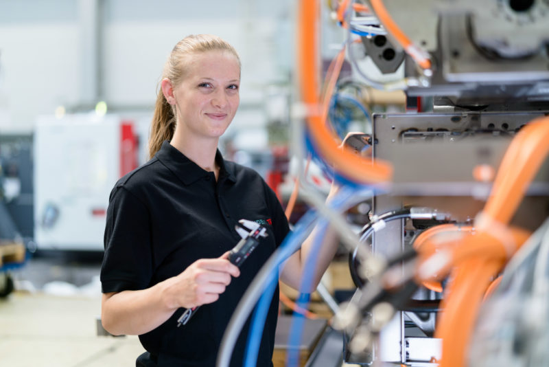 Industriefotografie: Junge Mitarbeiterin in der Fertigung von Werkzeugmaschinen bei einem mittelständischen Hersteller.