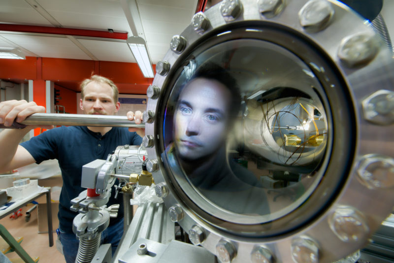 Science photography: An employee is mirrored in a glass seal during the preparation of an experiment in a vacuum chamber in the Department of Modern magnetic systems of the Max Planck Institute for Intelligent Systems in Stuttgart.