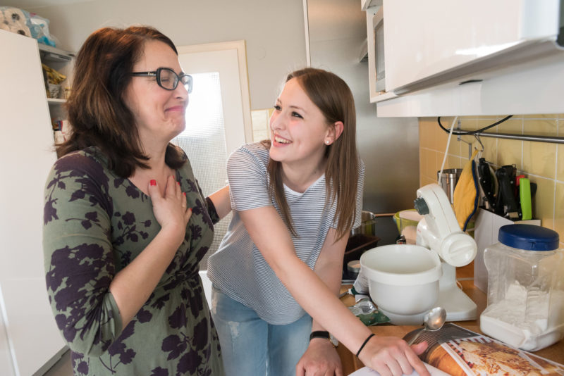 Reportagefotografie zum Thema Lernen und Bildung: Mutter und Tochter haben beim gemeinsamen Kuchenbacken in ihrer Küche zuhause großen Spaß.