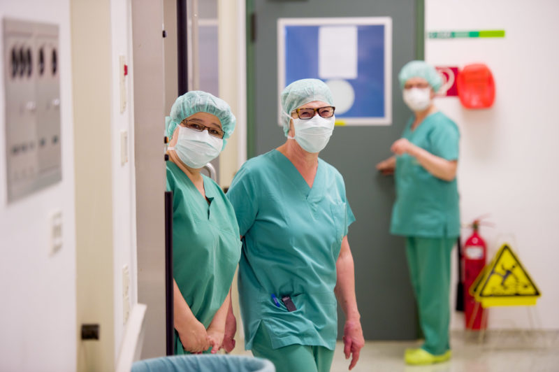Medizinfotografie: Operationsschwestern während einer Pause zwischen zwei Operationen. Sie freuen sich, dass ein Fotograf Ihre Arbeit begleitet.