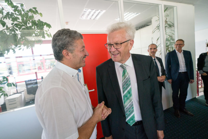 Fotoreportage - Besuch des Ministerpräsidenten bei einer mittelständischen Firma: Ministerpräsident Winfried Kretschmann begrüßt einen langjährigen Firmenmitarbeiter mit ausländischer Herkunft.