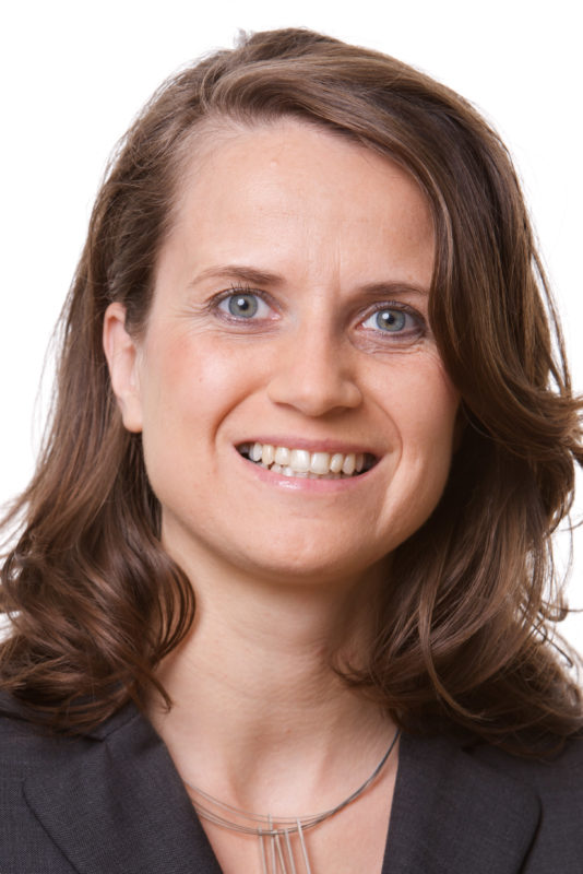 Portrait photography: Employee portrait against a white background. The photo was taken with studio flash in front of a white background. The assembly of the set took place on a corridor in the company.