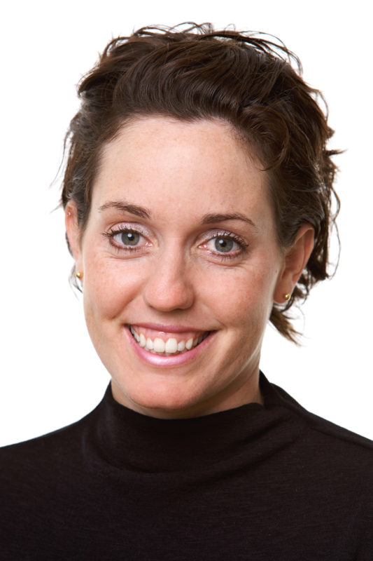 Portrait photography: Employee portrait against a white background. The photo was taken with studio flash in front of a white background. The assembly of the set took place on a corridor in the company.