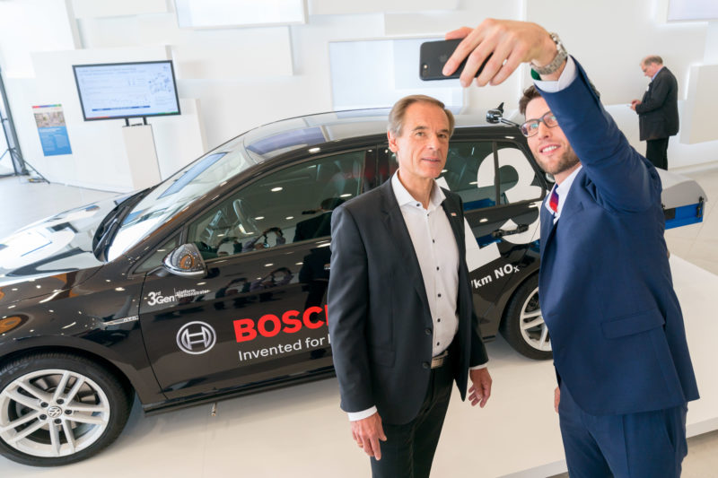 PR-Fotografie: Pressefotos auf der Pressekonferenz der Robert Bosch GmbH: Geschäftsführer Dr. Volkmar Denner macht zusammen mit einem Mitarbeiter ein Selfie vor einem umweltfreundlichen Dieselfahrzeug.