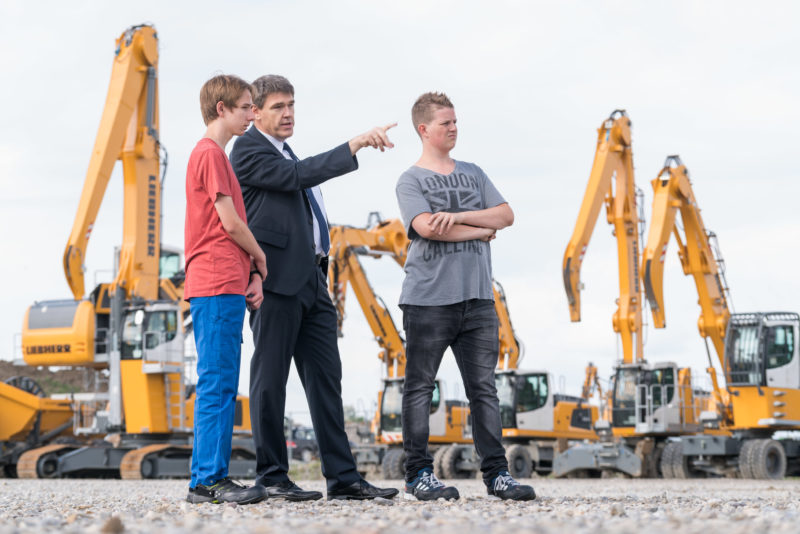 Reportagefotografie: Zwei Schüler bekommen während einem Praktikum bei der Firma Liebherr-Hydraulikbagger GmbH einen Eindruck von den Abläufen eines Industriebetriebes.