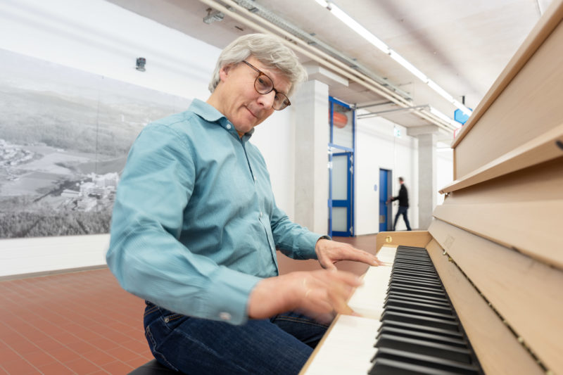 Reportage photography: scientists create artificial ivory: portrait of one of the scientists. He sits at the piano with keys made of the new material.