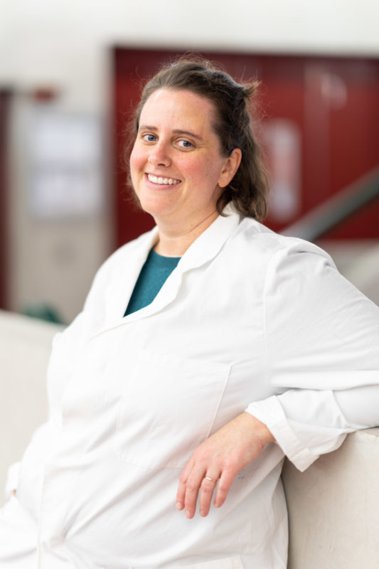 Reportage photography: Scientists create artificial ivory: Relaxed single portrait of the female scientist in her white lab coat.